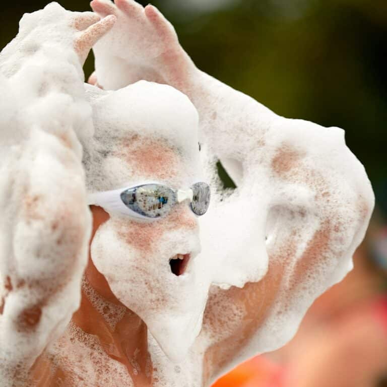 Face of a child in foam enthusiastic joyful child at a foam party, close-up of a child among the