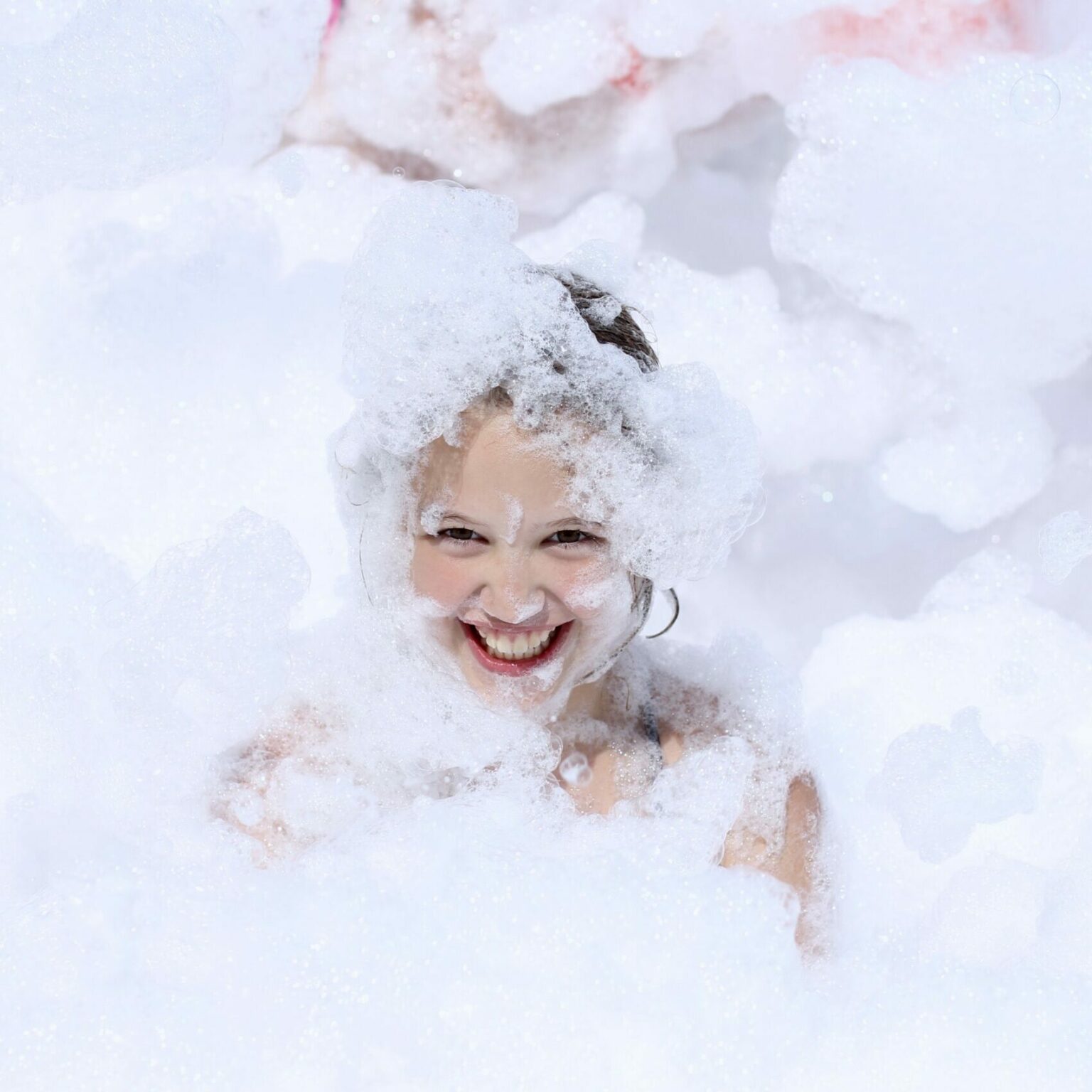 girl having fun playing in foam for birthday party scaled e1711052819562