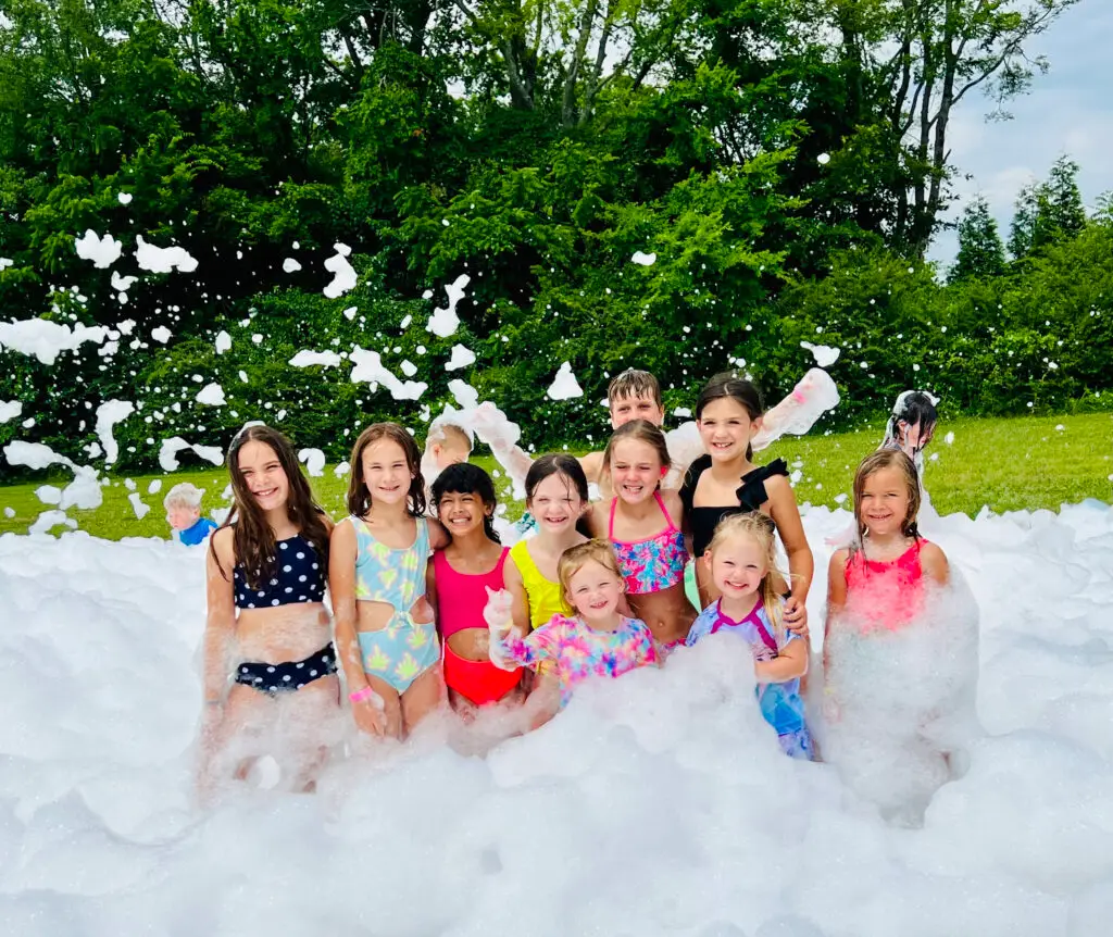 Summer camp kids smiling in deep foam at a foam day in Spring Hill, TN