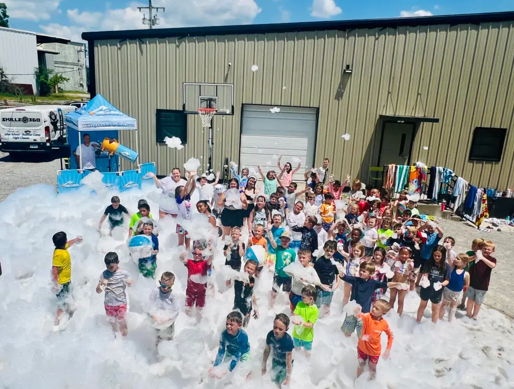 Large group of summer camp kids playing in deep foam