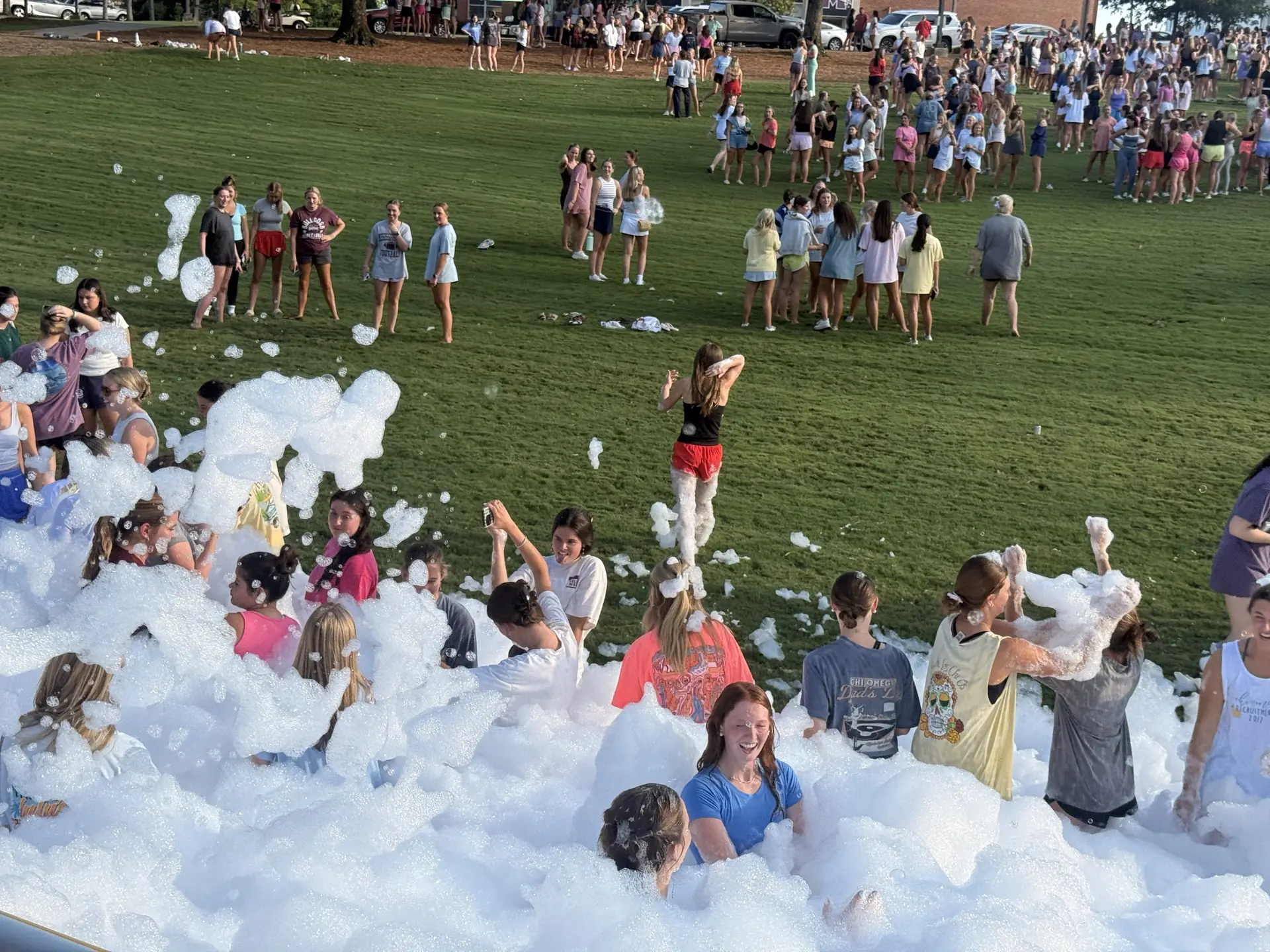 Large crowd of students playing in foam on a campus lawn in Athens, Alabama