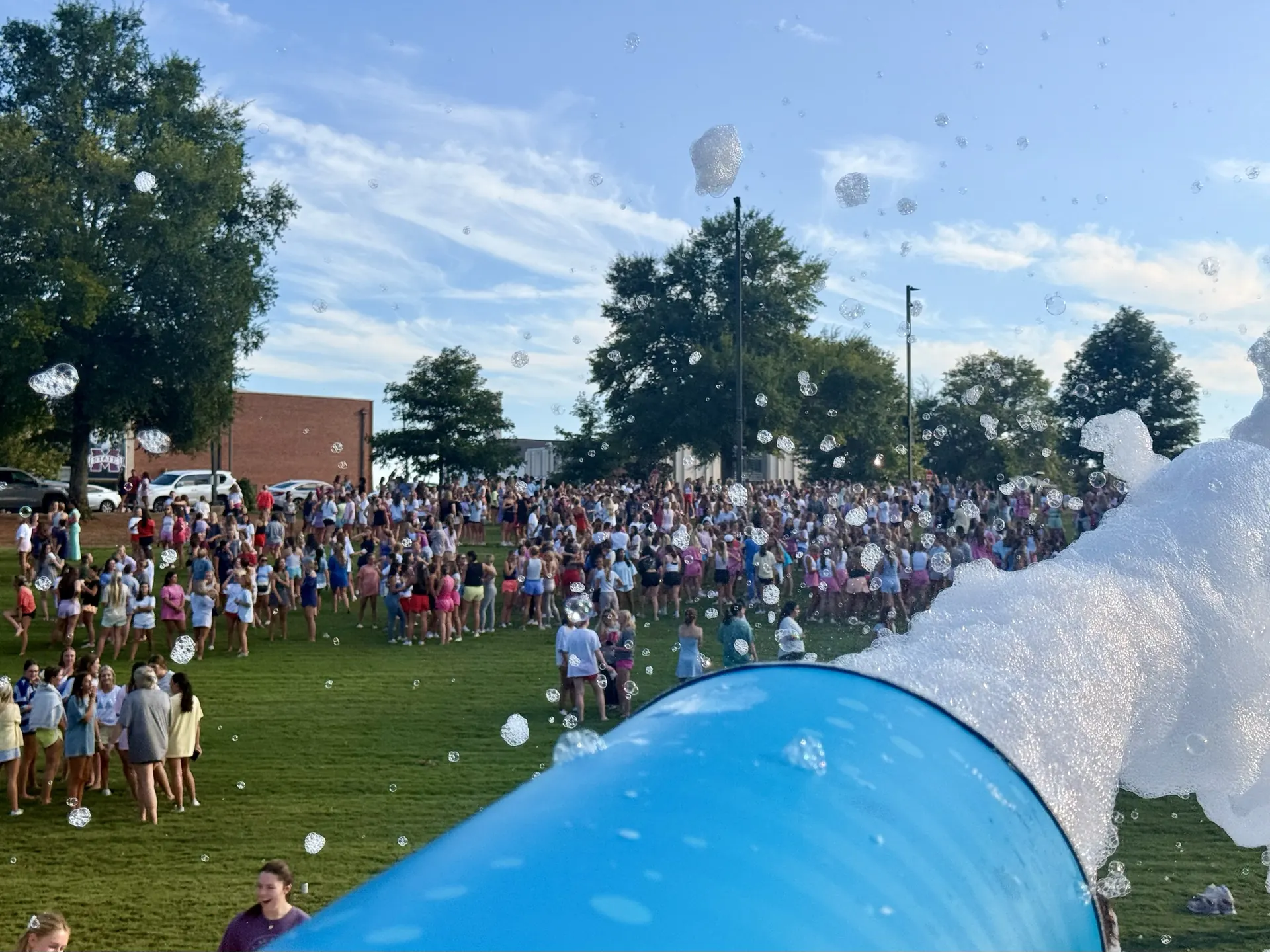Foam cannon spraying foam over a large student crowd at a campus event in Athens, Alabama