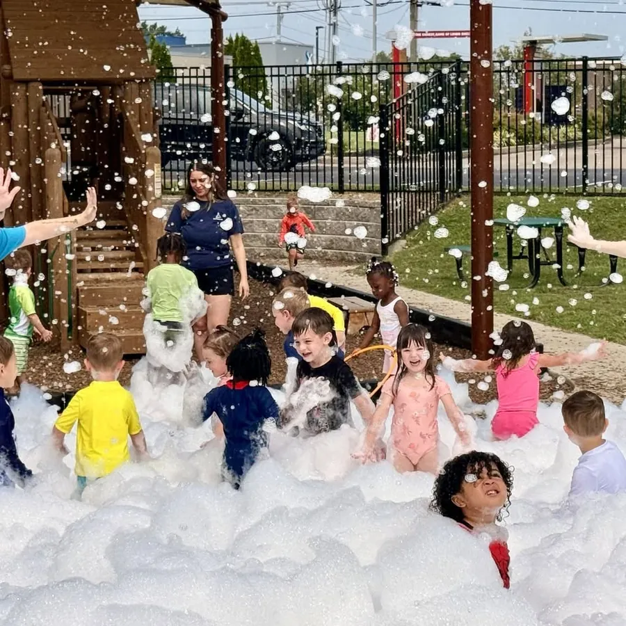 Daycare kids playing in foam on a playground