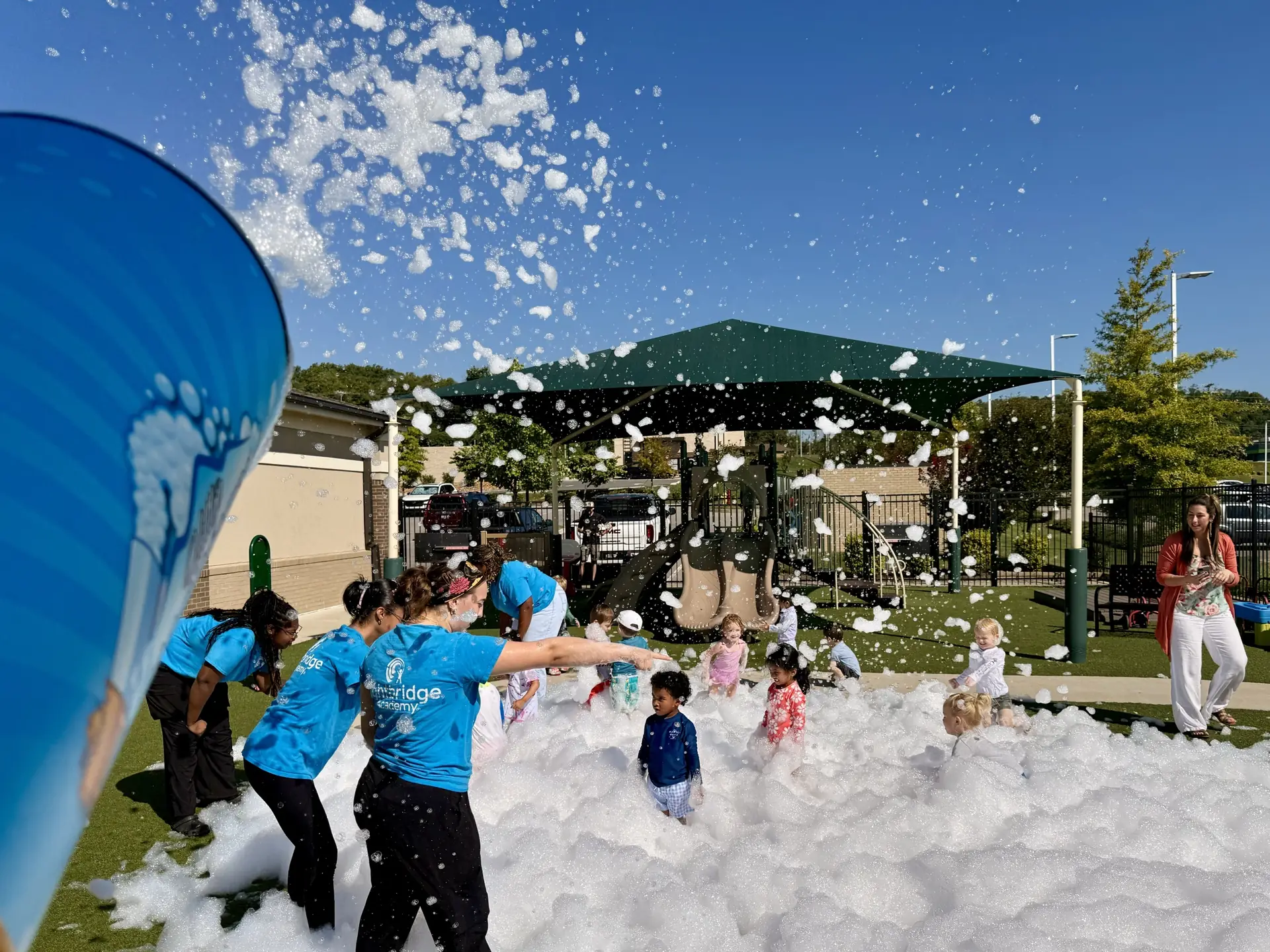 Hilltop team members in blue shirts playing in foam at an event in Hendersonville, TN