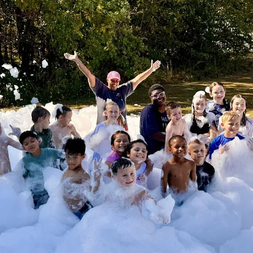 Group of kids posing in foam at a backyard party