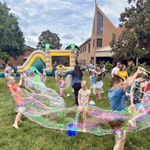 Child making a giant bubble at a church VBS event